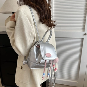 Silver mini backpack with pink drawstring and cute plush charm for women’s casual style