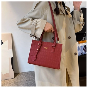 Mannequin avec sac cabas en cuir matelassé bordeaux avec lettrage doré et breloque cœur