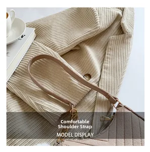 Close-up of brown crossbody bag with V-shaped stitching and gold chain strap detail