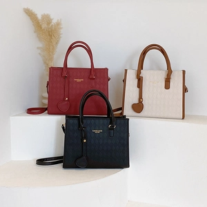 Tre eleganti borse tote in pelle trapuntata in rosso, beige e nero con ciondoli a cuore