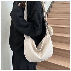 Detail of beige corduroy crescent crossbody bag with adjustable wide strap and round coin pouch
