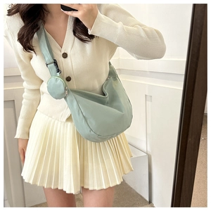 Close-up of mint green nylon crescent bag with wide strap and matching round coin purse