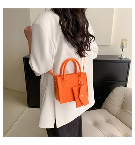 Orange felt tote bag with heart embossing and matching coin purse on a white blazer