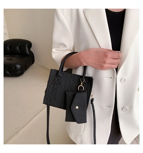 Detail of black embossed felt tote bag with gold hardware and mini envelope pouch