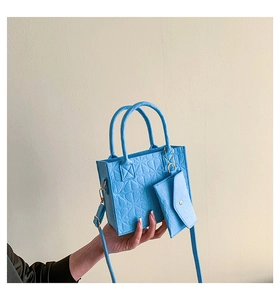 Detail of sky blue felt handbag set with textured surface and small matching pouch