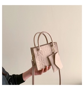 Detail of embossed floral pattern on beige felt tote bag with small matching purse