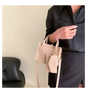 Detail of light pink felt handbag set featuring a geometric texture and matching coin pouch