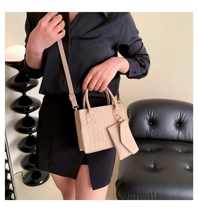 Detail of beige embossed felt tote bag with matching mini envelope pouch and gold hardware