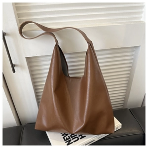 Détail du sac cabas marron en similicuir montrant la texture souple et la large bandoulière