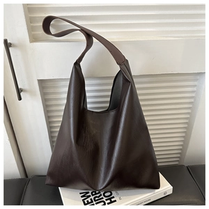 Détail d'un sac cabas marron foncé en similicuir avec grain et texture minimaliste