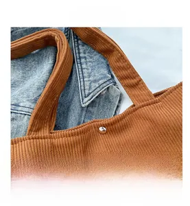 Detail of brown corduroy tote bag showing stitching and silver metal buckle closure