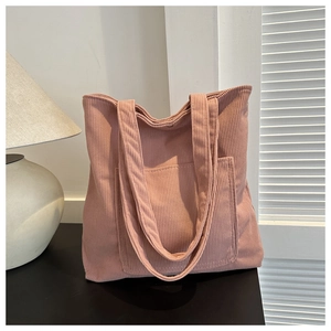 Détail du sac fourre-tout en velours côtelé rose avec poche frontale et texture