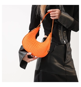 Detail van oranje hobo tas met krokodillenreliëf en goudkleurige metalen gesp-accenten
