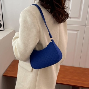 Navy blue quilted underarm bag with V-shaped stitching and a minimalist retro design