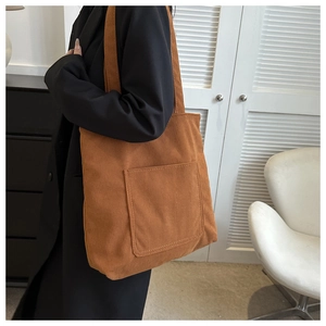 Detailed texture of brown corduroy tote bag with large front pocket for daily use
