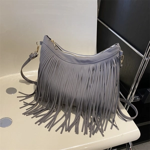 Grey vintage tassel shoulder bag with matte texture and gold zipper in minimalist setting