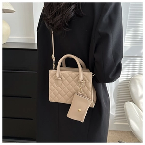 Side view of beige quilted crossbody bag with a small detachable coin purse on a model
