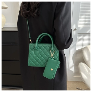 Detail of green quilted crossbody bag showing fine stitching and metallic buckle details