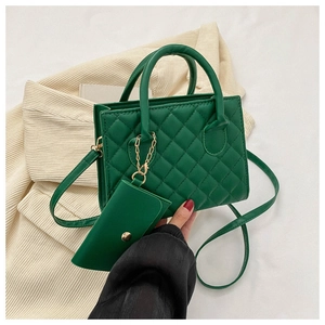 Detail of green quilted crossbody bag with golden hardware and matching mini coin purse charm