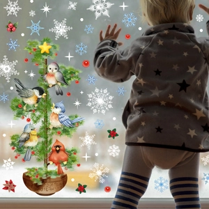 Close-up of Christmas window stickers featuring white snowflakes and birds on glass
