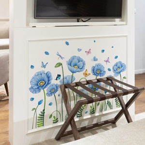 Detalle de vinilos decorativos de amapolas azules y mariposas en pared blanca