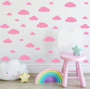 Detailed view of pink cloud wall stickers applied to a white wall in a cozy nursery room