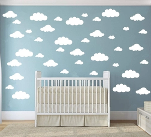 Nursery wall scene with white cloud decals in various sizes on a soft light blue wall
