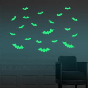 Luminous green bat wall stickers for Halloween decor glowing in a dark room setting