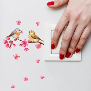 Detail of panda branch wall sticker showing birds on pink cherry blossom near a light switch