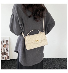Off-white woven texture flap bag shown with adjustable shoulder strap on a model