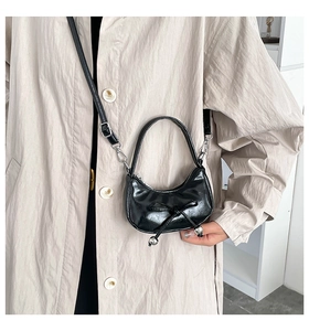 Détail du sac croissant noir avec nœud décoratif et perles argentées fines