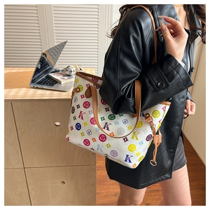 Détail du sac cabas imprimé avec des motifs colorés et une bandoulière marron élégante