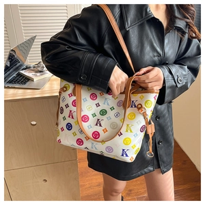 Gros plan sur un grand sac cabas avec imprimés monogrammes colorés et anses en cuir