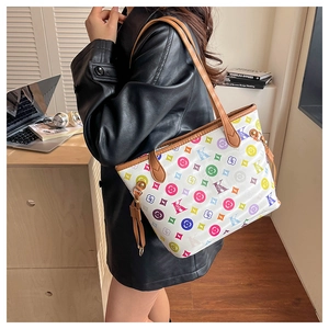 Détail d'un cabas blanc avec imprimé lettre K coloré, motifs floraux et anses en cuir