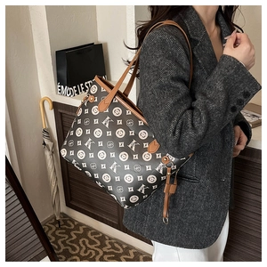 Détail du grand sac cabas imprimé avec lanières en cuir sur une veste de costume grise