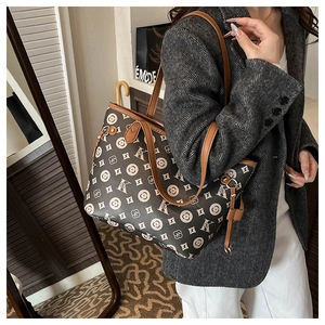 Détail d'un cabas vintage en cuir marron à monogramme avec pompon et grande capacité de rangement