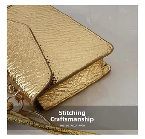 Macro shot of gold snakeskin textured leather bag showing precise stitching and metallic buckle