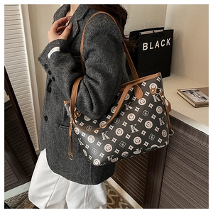 Détail d'un grand sac cabas avec motifs K et S porté par un mannequin en blazer gris chic