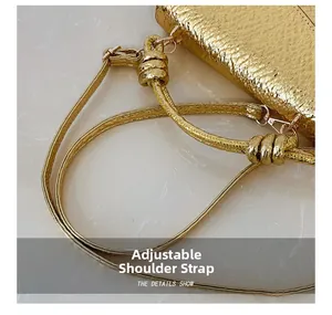 Detail showing the adjustable shoulder strap and gold metallic texture of the square bag