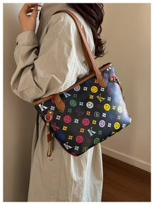 Vue latérale d'un grand sac cabas avec imprimé monogramme coloré et anses en cuir