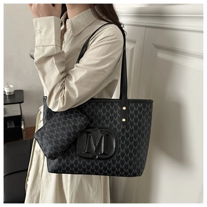 Detail der schwarzen Monogramm-Tote-Bag mit goldenem M-Logo und geräumigem Schultergurt