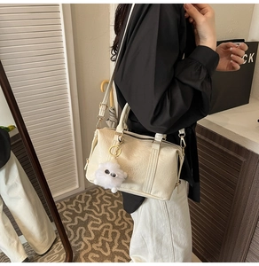 Detalle de bolso crema en cuero plisado con cremallera dorada y logo fashion air paris