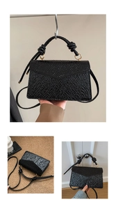 Detail view of black ripple textured crossbody bag with metal ring handle and strap