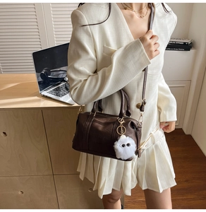 Maillard brown leather pillow bag with a funny plush eyes charm on a white blazer outfit