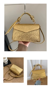 Detail of gold metallic textured crossbody bag with unique knot handle and pleated finish