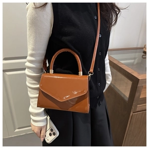 Glänzende braune Lacklederhandtasche mit Umschlagklappe und goldenen Metallelementen