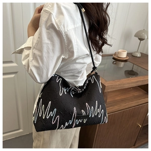 Détail du sac cabas noir en tissu texturé avec broderie ondulée aux couleurs vives