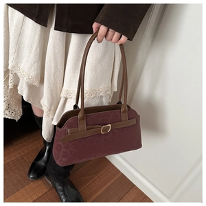 Macro shot of vintage burgundy faux suede bag with subtle leopard print and gold buckle