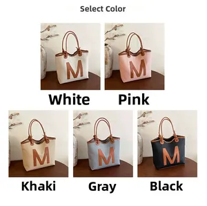 Selection of trendy woven tote bags featuring large leather M patch in five elegant colors