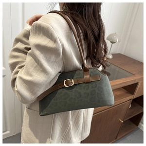 Olive green leopard print shoulder bag worn by model in a minimalist home setting